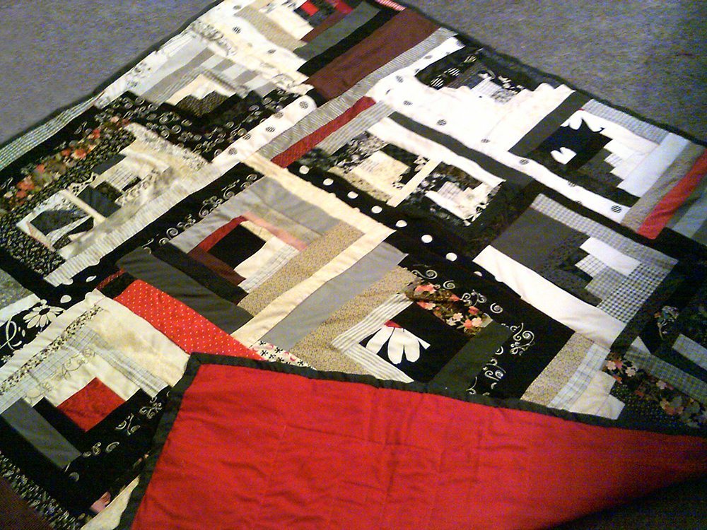 62" x 62" all cotton pieced red, black and white quilt, machine quilted with red cotton backing $250